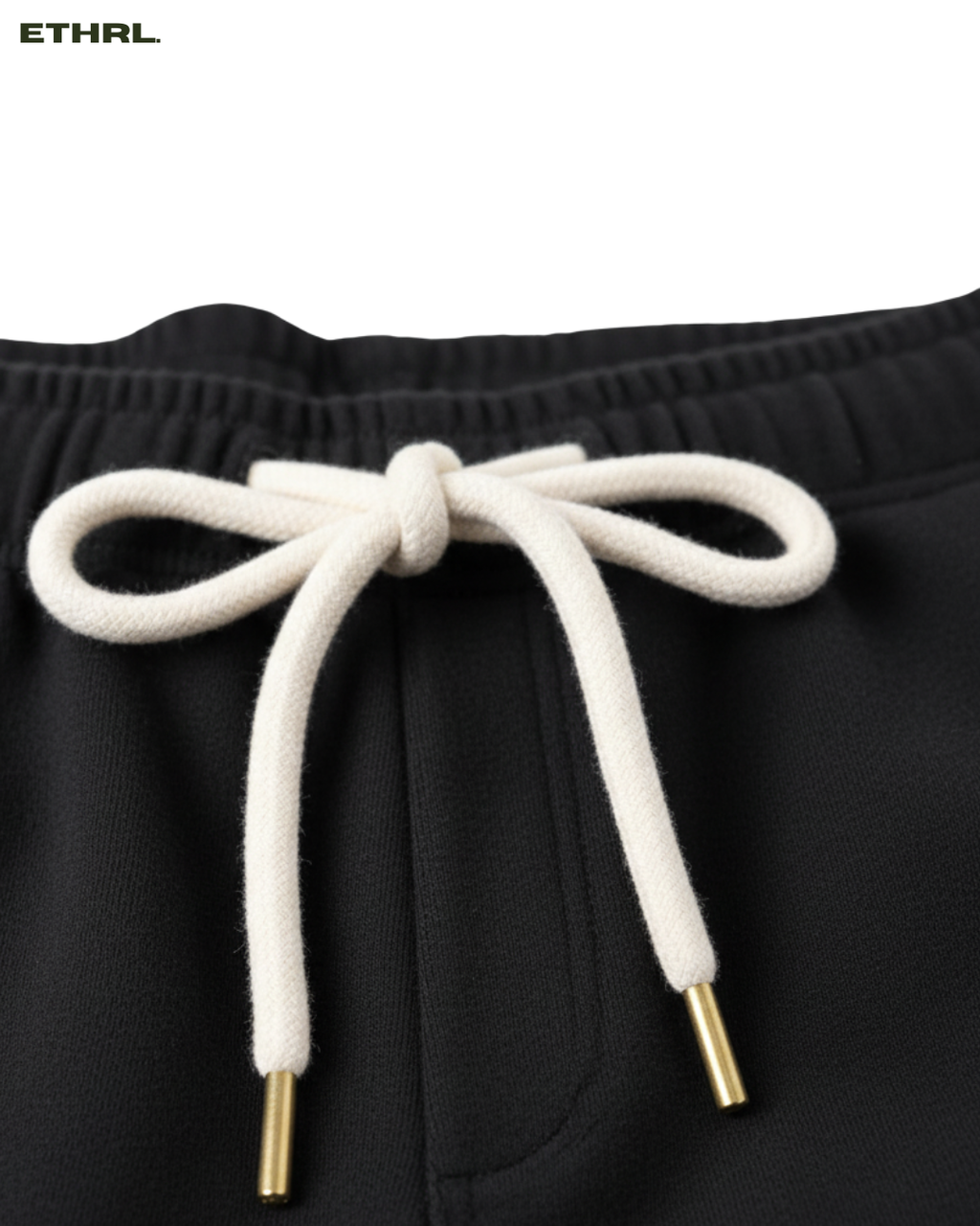 Black shorts with white drawstring and gold tips on a white background, featuring the brand 'ETHRL'.